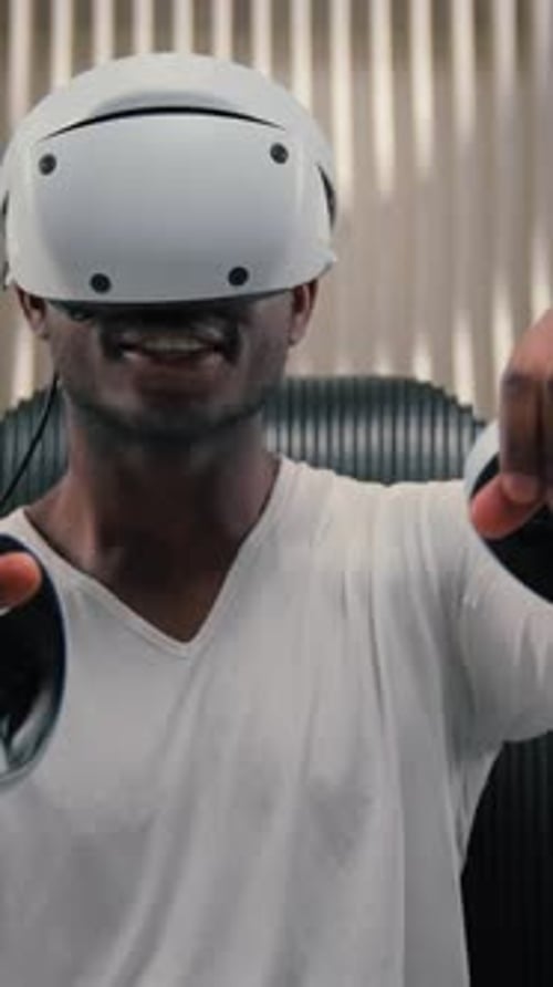 Man Wearing VR Headset and Holding Controllers