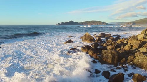 Powerful Ocean Waves Crashing Against Rocky Coastline at Sunset