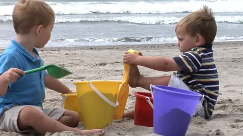 Two young boys playing with beach toys