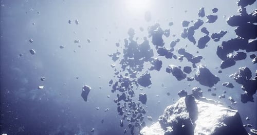 Asteroid Belt Floating in Space with Sunlight Illuminating Fragments