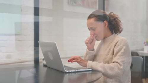 Woman Working on Laptop Coughing