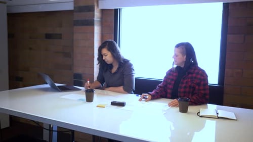 Businesswomen in scrum meeting collaborate on strategy in modern office