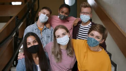 Young multi ethnic students wearing face masks return to university after covid pandemic