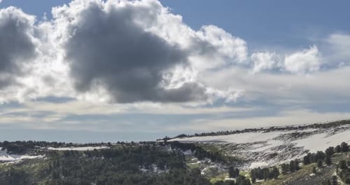 Time Lapse of Cloudscape Behind of the Mountains Top Snow Rocks Cliffs and Deep Blue Sky High