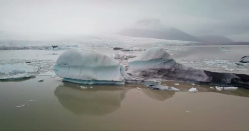 Luftaufnahme eines Eisbergs in der Lagune mit Gletscher im Hintergrund. Island.