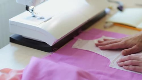 Fashion designer in studio creating a new dress with pattern and chalk