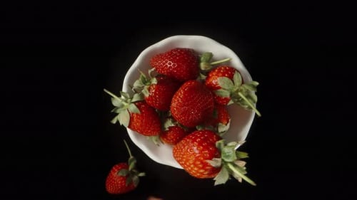 Strawberries rotate on a plate. I take a handful and bring it to the camera. Macro, accelerated shoo