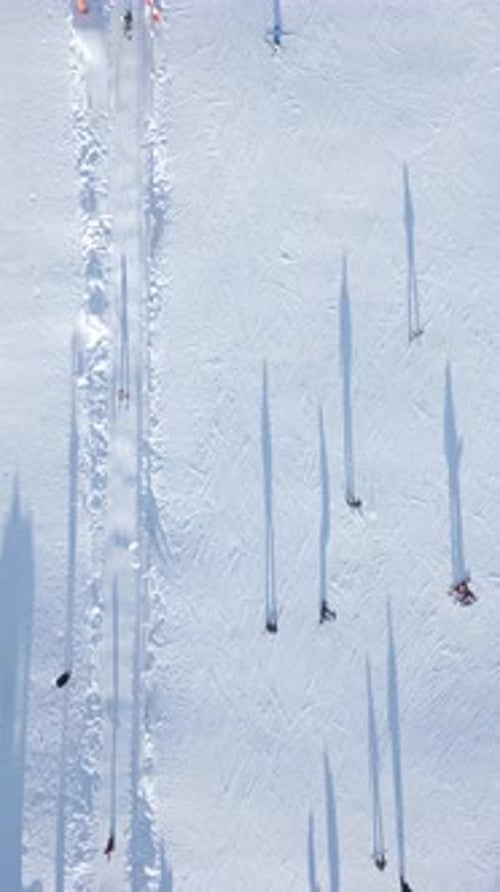Skiers and Snowboarders Skiing on a Snow Slope with a Ski Lift at the Ski Resort