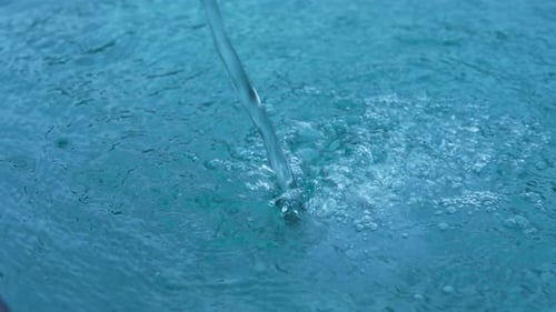 Clear Water Pouring into Blue Pool