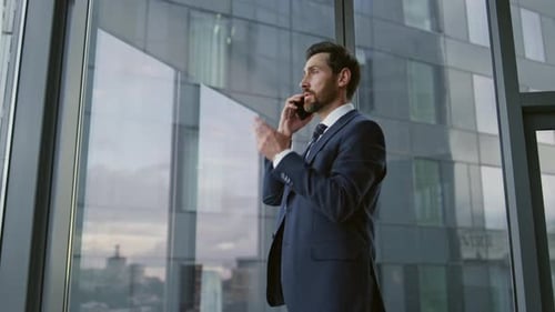 Worried Ceo Calling Phone Standing Near Office Window Close Up. Confident Bearded