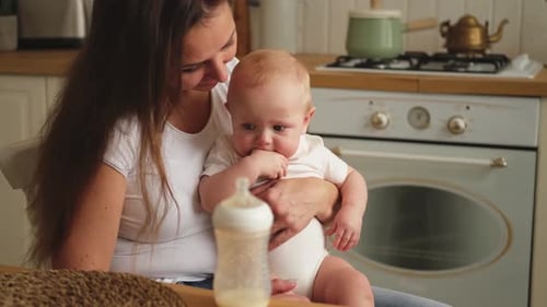 Affectionate Parent Holds Adorable Baby in Kitchen