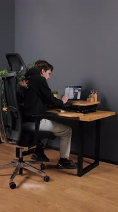 Young Adult Working at Laptop in Modern Office