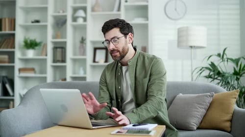 Man on Laptop Works from Home on Couch