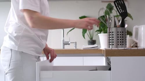 Open the kitchen drawer with cutlery. organization of space in the kitchen. Put the spoons, knives,