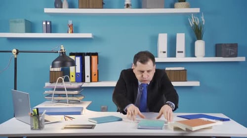 Der Geschäftsmann kommt in sein Büro und putzt seinen Schreibtisch.