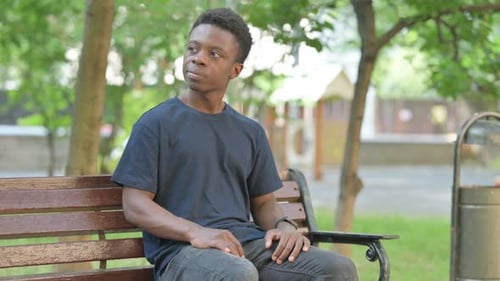 Young Adult on Park Bench Checks Time