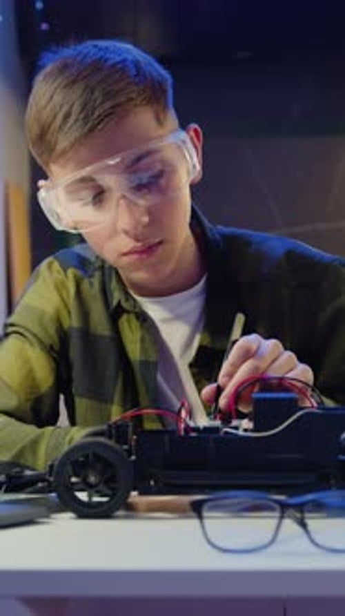 Smart Kid Assembling and Testing Electric Circuit Building and Programming Car Boy Repairing His