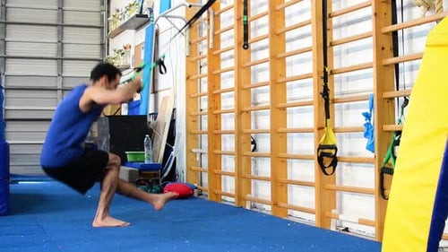 a still shot of a guy doing pistol squats
inside a gymnastics gym