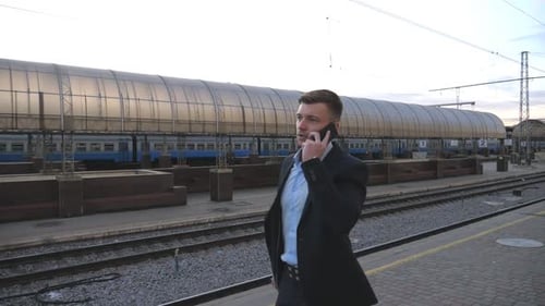 Successful Businessman Walking Through Railway Station and Talking on Phone Handsome Man Strolling