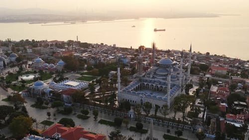 La Mosquée bleue brille dans la chaude lumière du soir alors que le soleil se reflète sur la mer de Marmara, mettant en valeur
