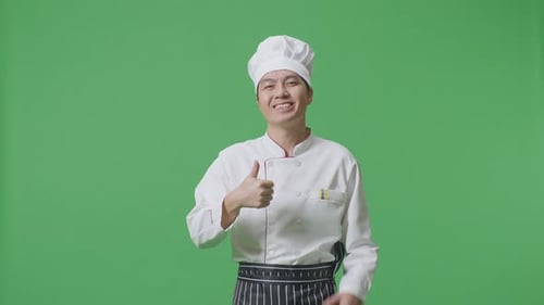 Asian Man Chef Smiling And Showing Thumbs Up Gesture To Camera While Standing In The Green Screen