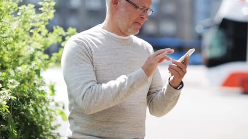 Senior man outside using smartphone to talk