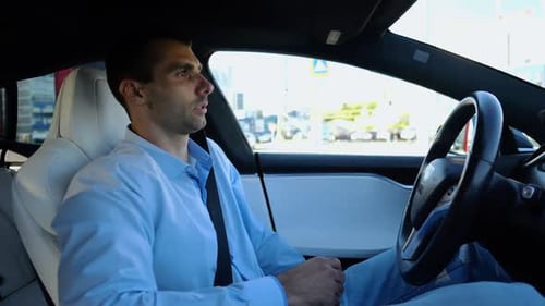 Male Businessperson Experience to Ride an Autonomous Self Driving Electric Car at Urban Road