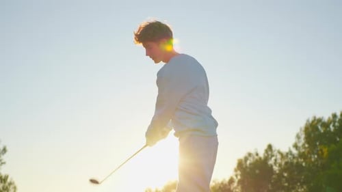 Teenage Golfer Practicing Swing at Golden Hour
