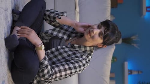 Woman Rubbing Neck and Face Indoors at Night