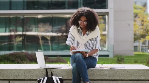Woman Studying Outside Modern Building Using Tablet