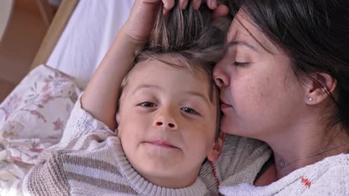 Loving Mother Kisses Cute Son on the Head