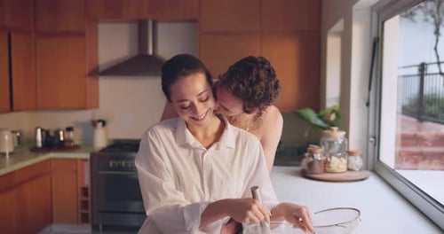 Loving Couple Embracing While Cooking in Kitchen