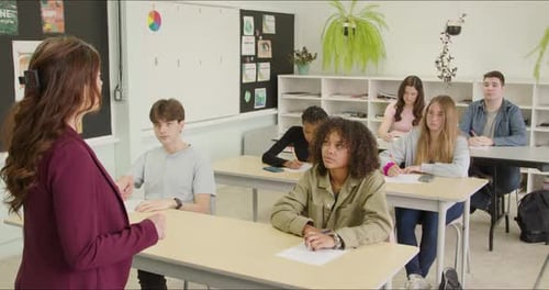 Students Learning in School Class Room. High School or College Class Raising Hand Asking Questions