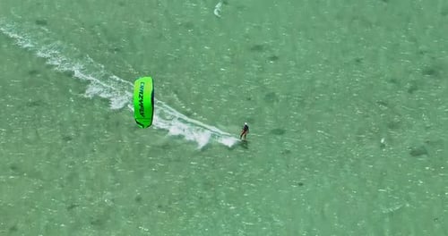 Aerial View of Kitesurfer Speeding with Kite in Clear Crystal Water Kitesurfer Rides a Kite in the