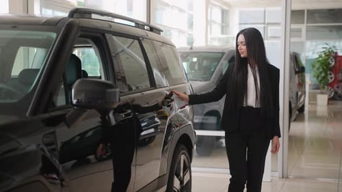 Saleswoman Showing Car Features in Dealership