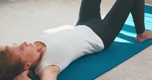 Fitnessstudio zu Hause. Junge schlanke Frau trainiert zu Hause. Kaukasische Frau trainiert im hellen Raum