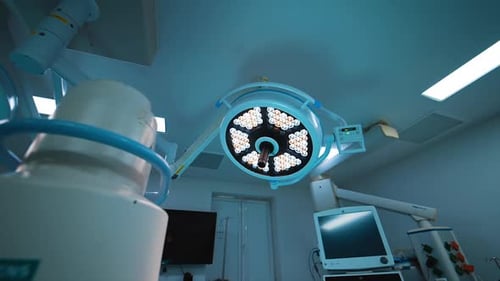 Two types of lamps illuminating the modern surgery room. Low angle view on the equipment.