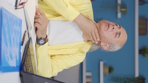 Vertical video of Home office worker old man suffering from sore throat.
