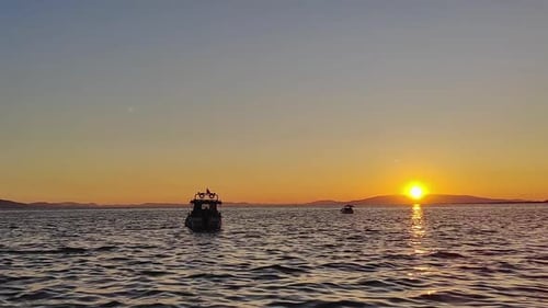 Pleasure Boat Standing Toward The Horizon At Sea At Sunset