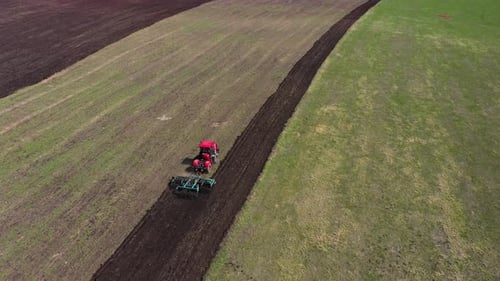 Red Tractor Working at Field
