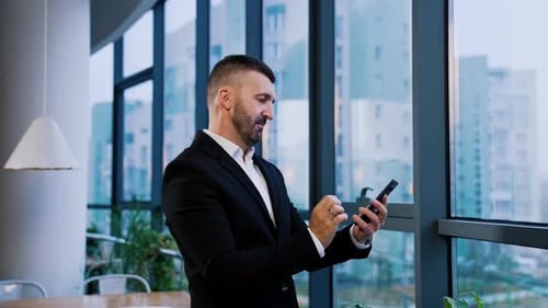 Man Using Smartphone in Modern Urban Office