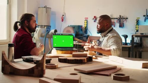 Craftsperson and Coworker Designing Custom 3D Furniture on Chroma Key Notebook