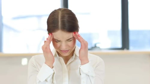 Young Woman Massaging Temples due to Headache
