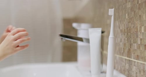 Niño buscando un cepillo de dientes en un baño moderno