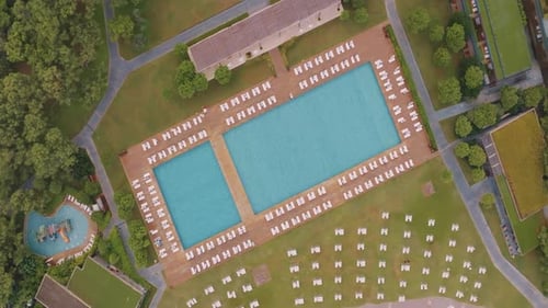Sonnenliegen und Sonnenschirme rund um den Pool, Ansicht von oben