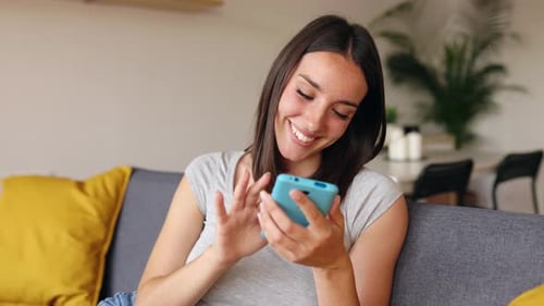 Woman Using Mobile Phone on Couch Indoors