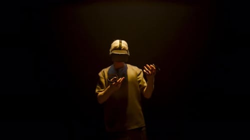 Young Adult Using Virtual Reality Headset in Dark Room