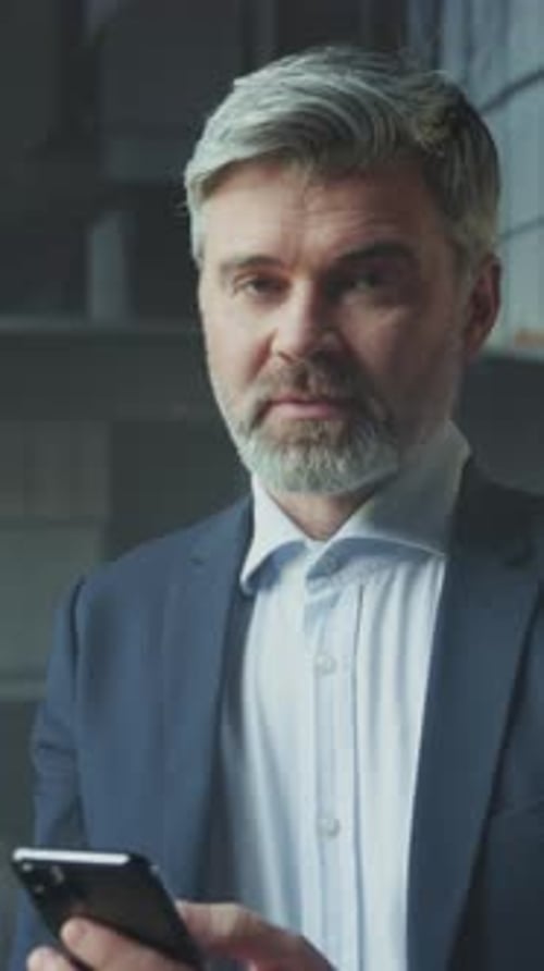 Smiling Man with Beard in Suit Uses Phone
