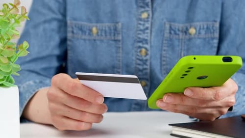 Compras en línea. Usar una tarjeta de crédito y un teléfono inteligente para pagar productos en una tienda en línea. El teléfono