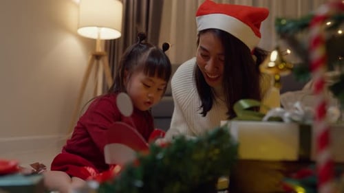 Smiling Mother and Child Open Christmas Gifts